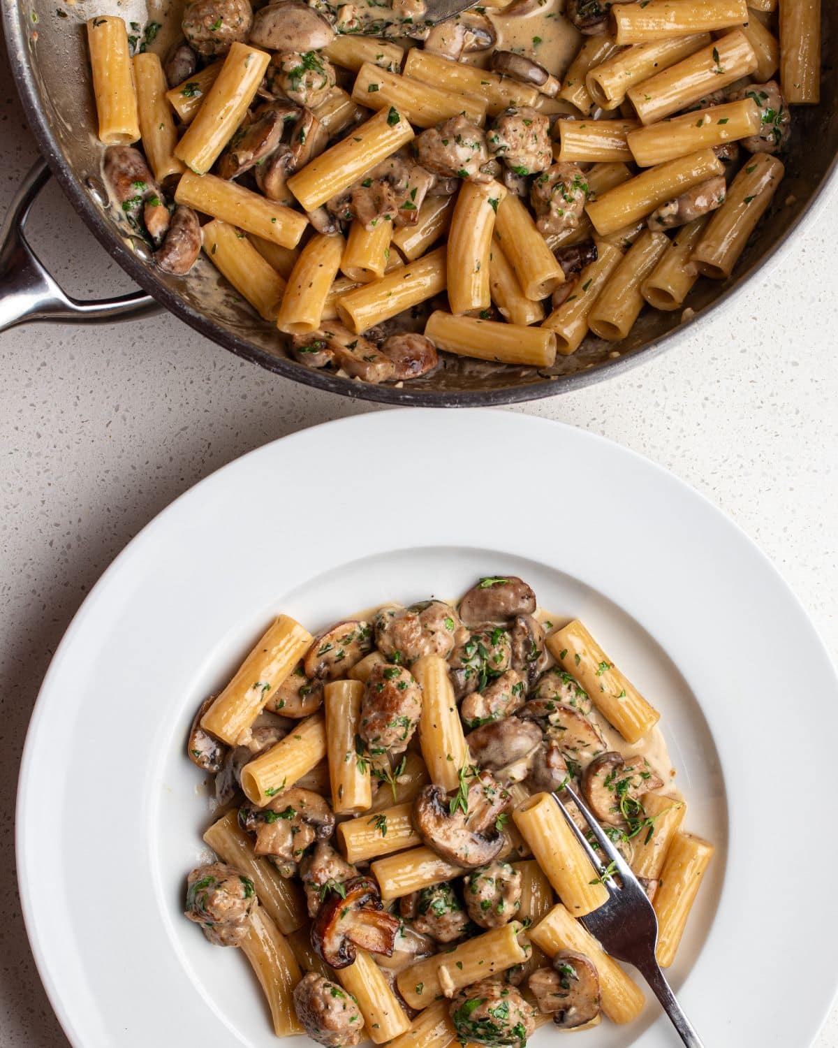 Creamy sausage and mushroom pasta in a dark bowl